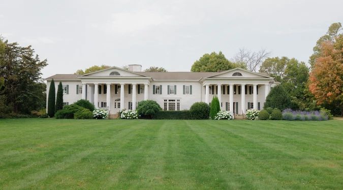Cedarhurst Mansion seen across its lawn, white columns and gardens
