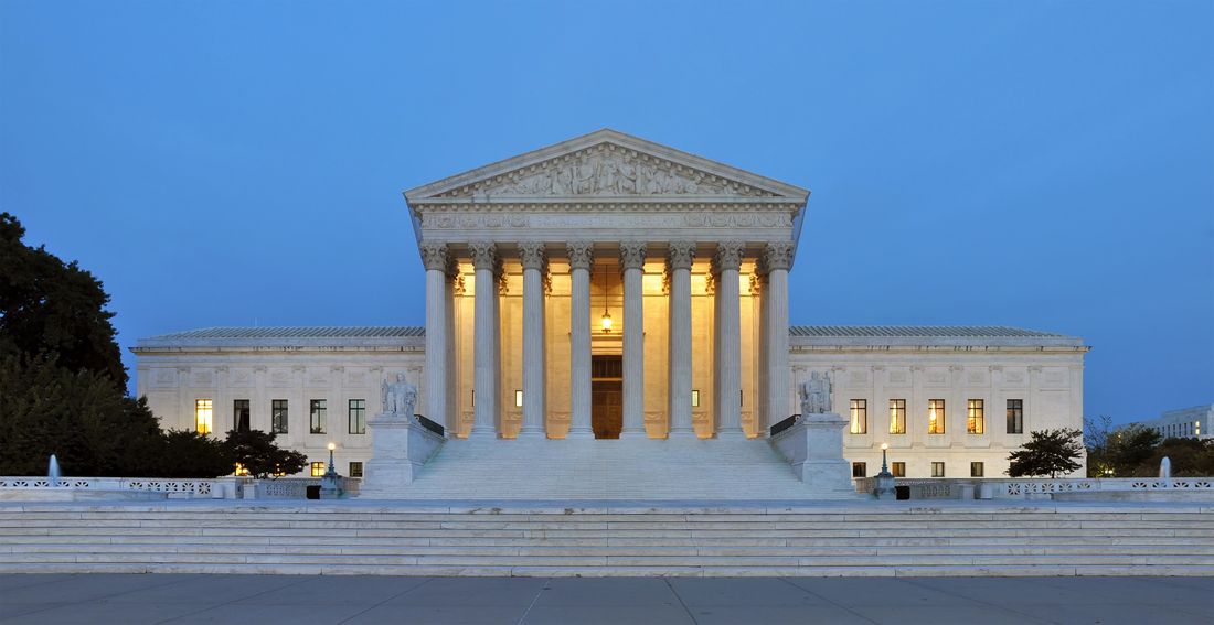 The Supreme Court Building in Washington at dusk, its columns lit from within