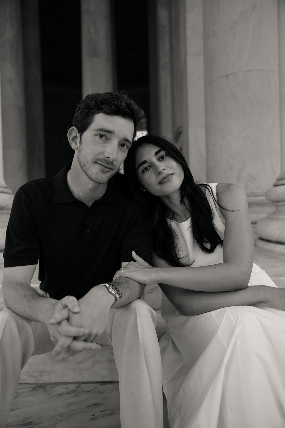 Black and white portrait of Joseph and Filiz seated together on marble steps, her head resting on his shoulder