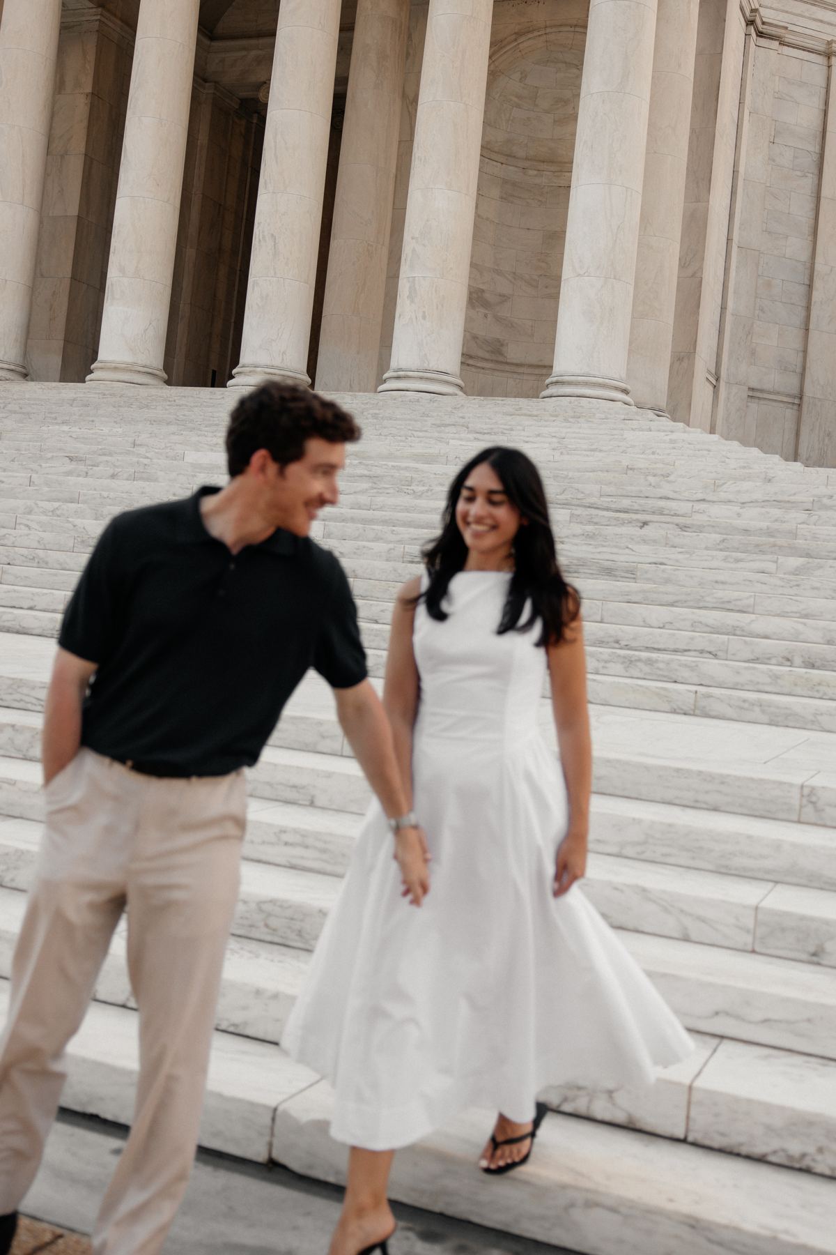 Joseph leading Filiz down the white marble steps of the Jefferson Memorial, both smiling